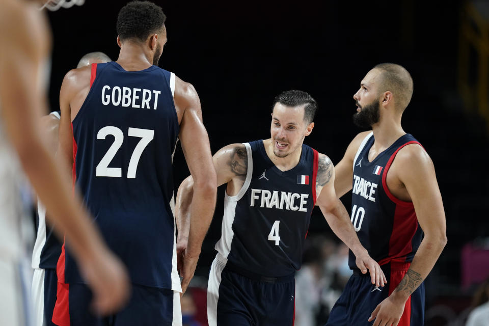 France's Thomas Heurtel (4) celebrates with teammates Rudy Gobert (27) and Evan Fournier (10) at the end of a men's basketball quarterfinal round game against Italy at the 2020 Summer Olympics, Tuesday, Aug. 3, 2021, in Saitama, Japan. (AP Photo/Charlie Neibergall)