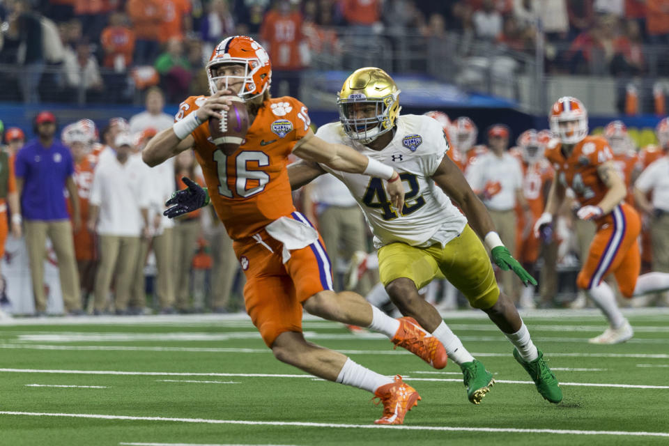 Clemson Tigers QB Trevor Lawrence (16) gets chased by Notre Dame Fighting Irish defensive lineman Julian Okwara (42) during the CFP semifinal last season. (Getty)