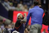 Nick Kyrgios, of Australia, places eye drops in his eyes after receiving them from medical staff in his match against Daniil Medvedev, of Russia, during the fourth round of the U.S. Open tennis championships, Sunday, Sept. 4, 2022, in New York. (AP Photo/Adam Hunger)