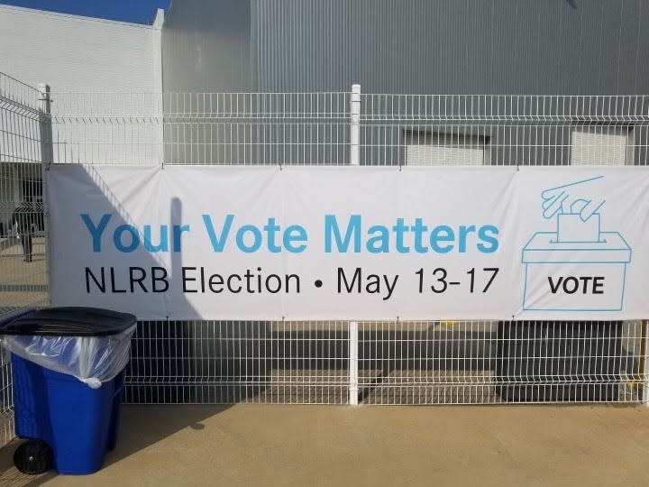 Two sides of the banner posted at the Vance Mercedes-Benz plant recently, with the one that was facing outward showing a blank vote box, while the one facing inward pictured a box marked No.