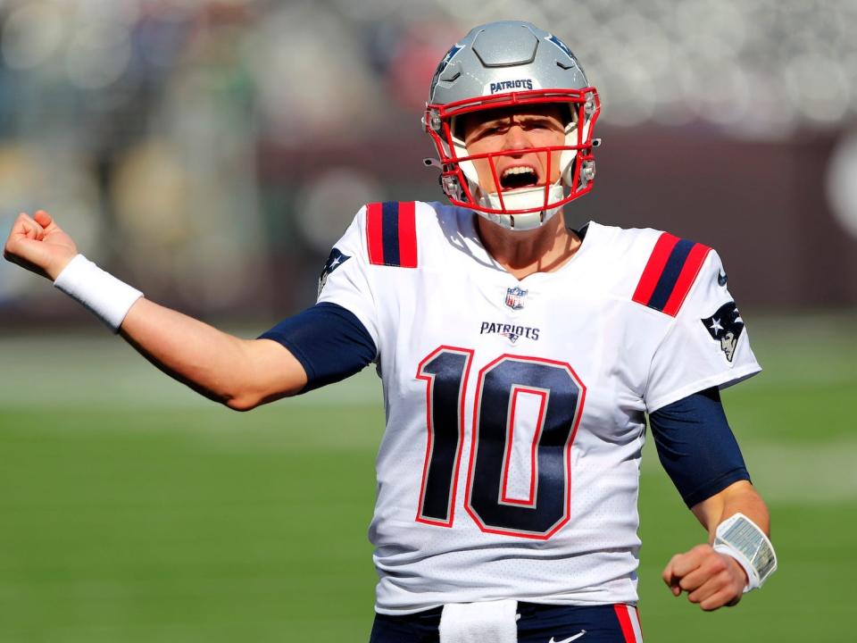 Mac Jones pumps his fist and yells during a Patriots game.