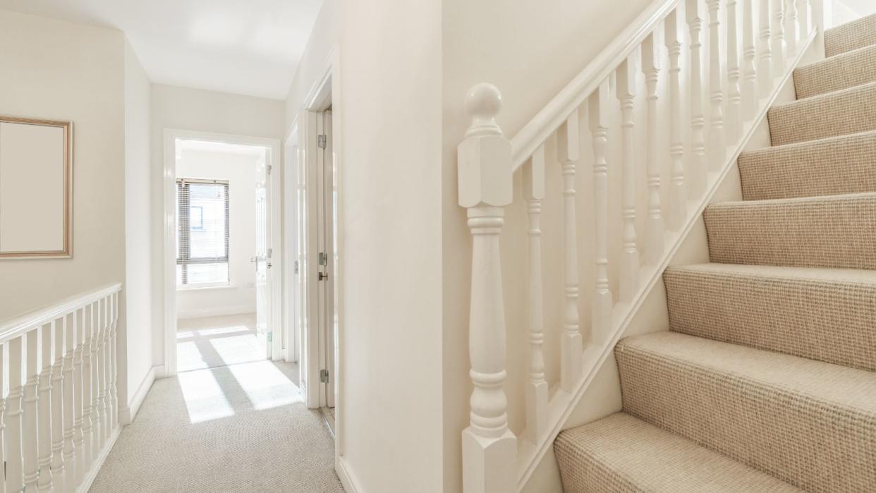  A white stairway with stairs going up 