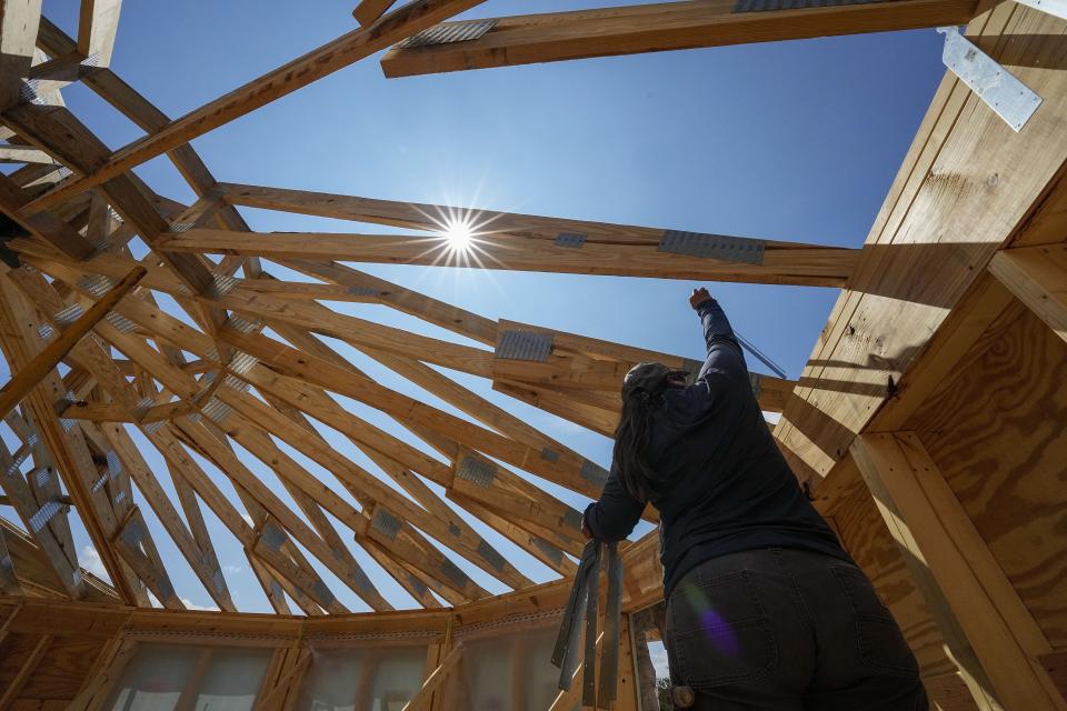 Workers build a home Tuesday, Sept. 19, 2023, in Marshall, N.C. Climate change is increasing billion-dollar disasters, many of them from intensifying hurricanes. Housing developers are now building homes, some of them round, that can resist hurricane-force winds and at the same time generate much less of the emissions that contribute to climate change. (AP Photo/Chris Carlson)