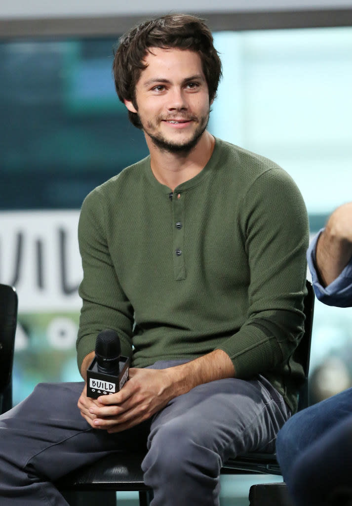 Dylan O'Brien smiling and holding a mic