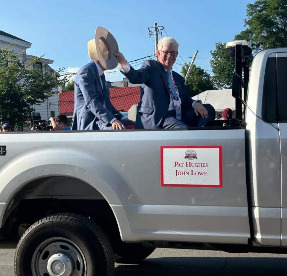 Former Free Press sports writer John Lowe waves to the crowd during the Baseball Hall of Fame parade on Saturday in Cooperstown, New York.