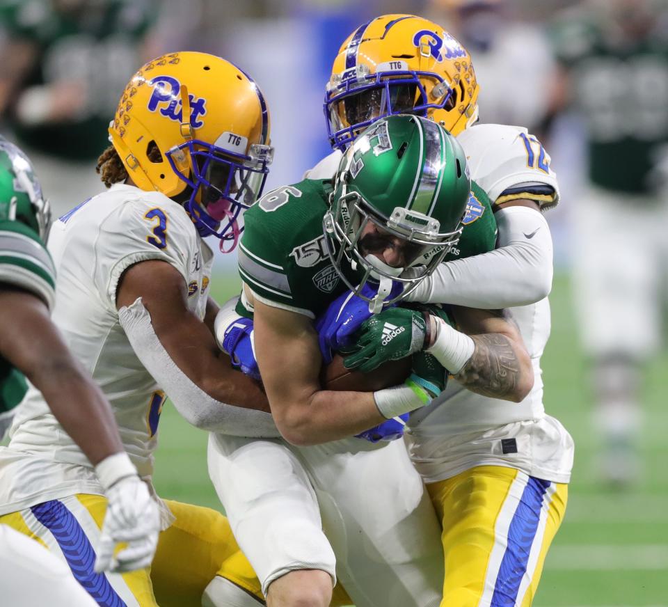 Eastern Michigan Eagles receiver Hassan Beydoun is tackled by Pittsburgh Panthers defensive backs Damar Hamlin (3) and Paris Ford (12) during the first half of the Quick Lane Bowl, Thursday, Dec. 26, 2019 at Ford Field in Detroit.