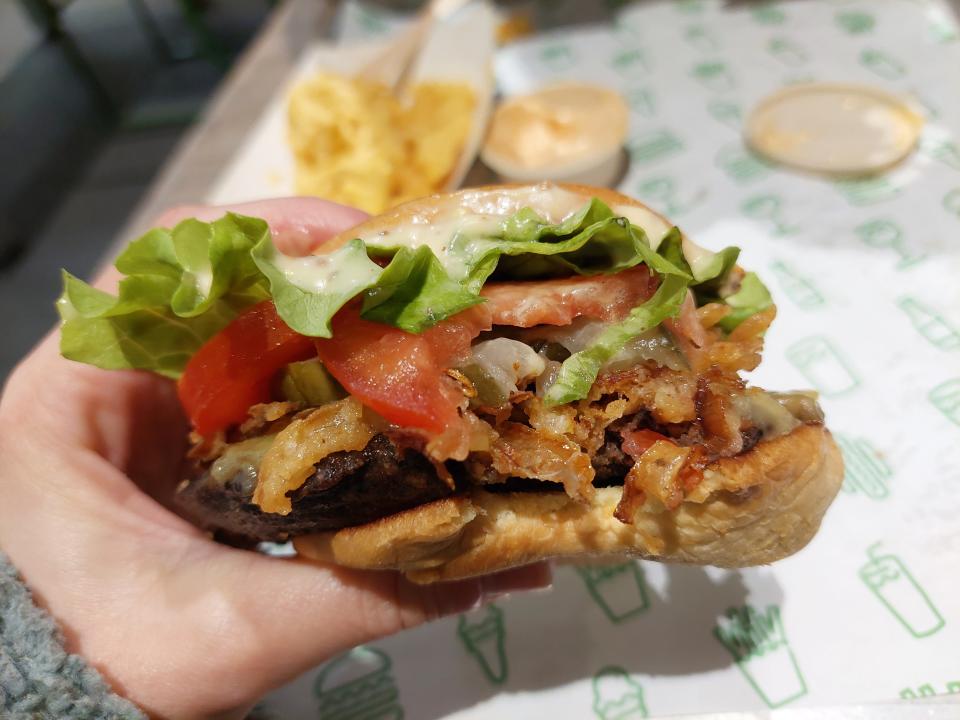 The crispy shallot vegan burger from Shake Shack, bitten into