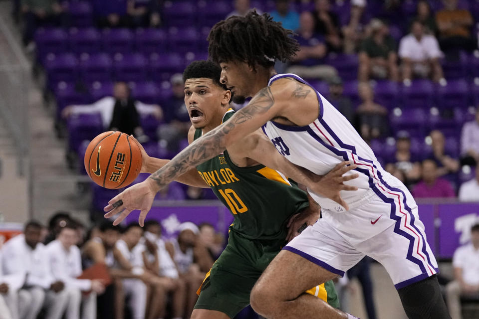 Baylor's RayJ Dennis (10) advances the ball upcourt under pressure from TCU guard Micah Peavy, right, in the second half of an NCAA college basketball game in Fort Worth, Texas, Monday, Feb. 26, 2024. (AP Photo/Tony Gutierrez)