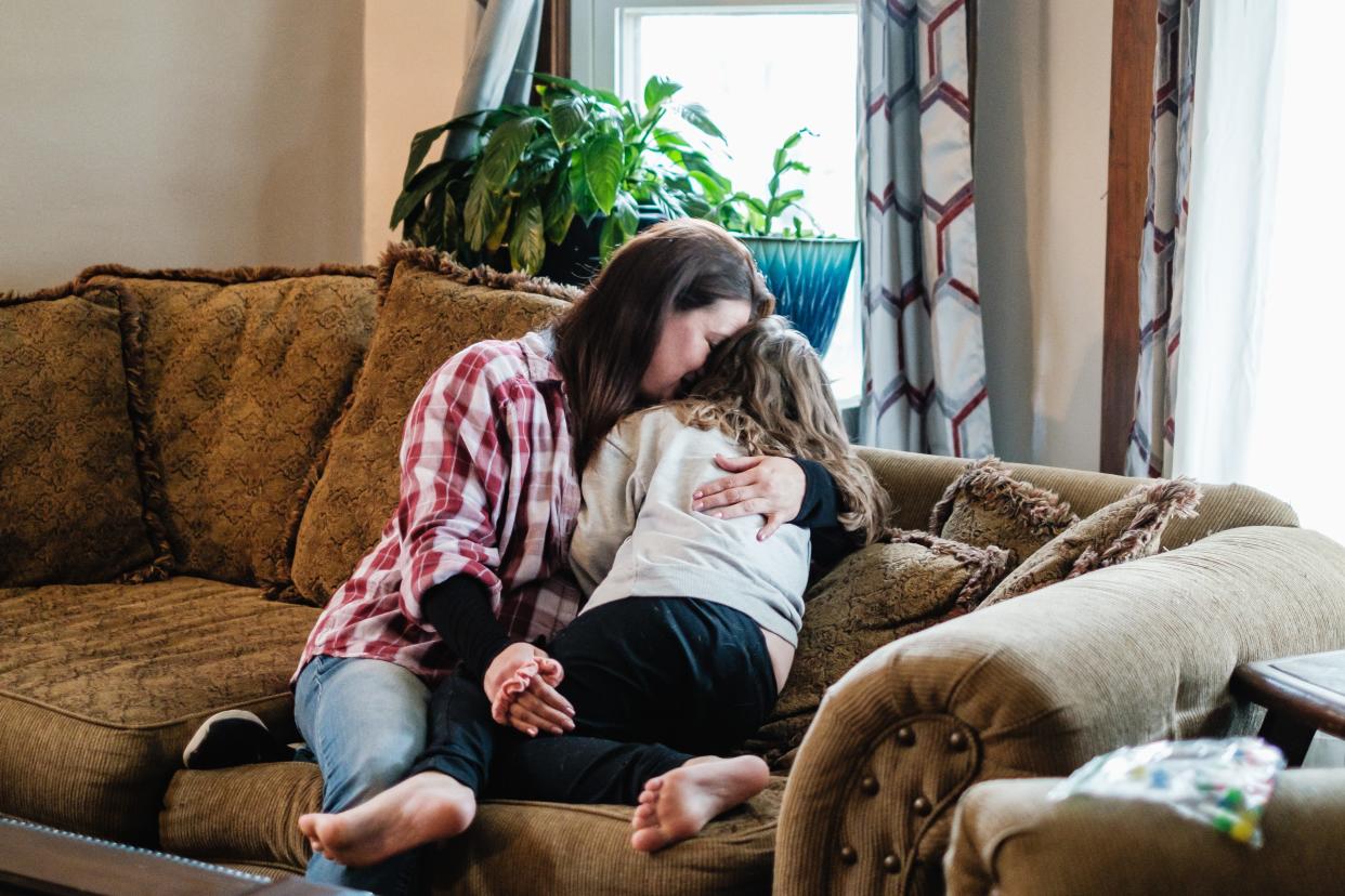 Heather Pereces, snuggles her daughter Bella, 6, in their Uhrichsville home.