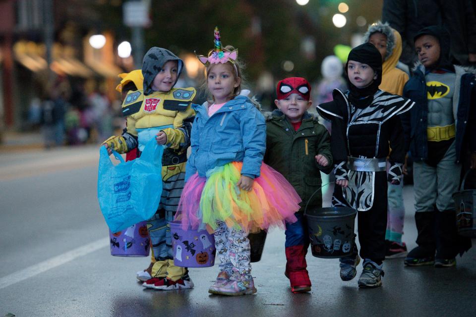 Kids in costume wait Wednesday night for the Halloween parade to start along Third Avenue in New Brighton.