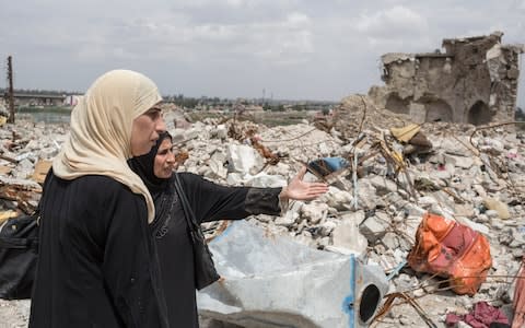 Byda'a Thanoon, 47, and sister Khawla Thanoon, 57, look for where their mother may be buried under the rubble near their destroyed house in the old city of Mosul - Credit: Sam Tarling for The Telegraph