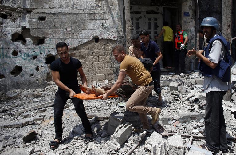 Palestinian medics evacuate a body from Gaza's eastern Shejaiya district on July 20, 2014