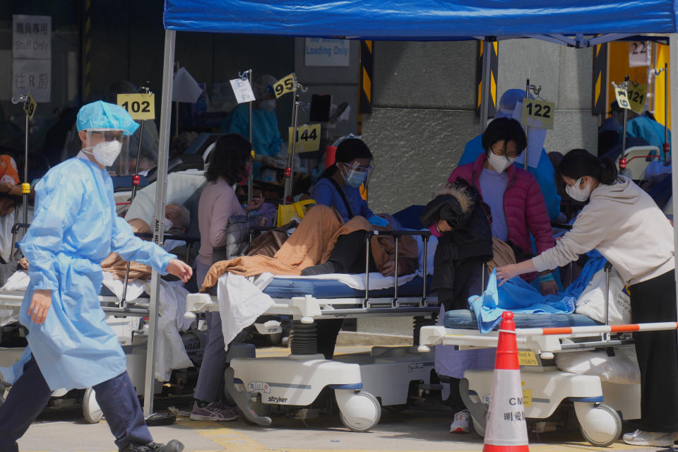 Patients in hospital beds wait at temporary holding area outside Caritas Medical Centre in Hong Kong, Monday, Feb. 28, 2022. (AP Photo/Vincent Yu)