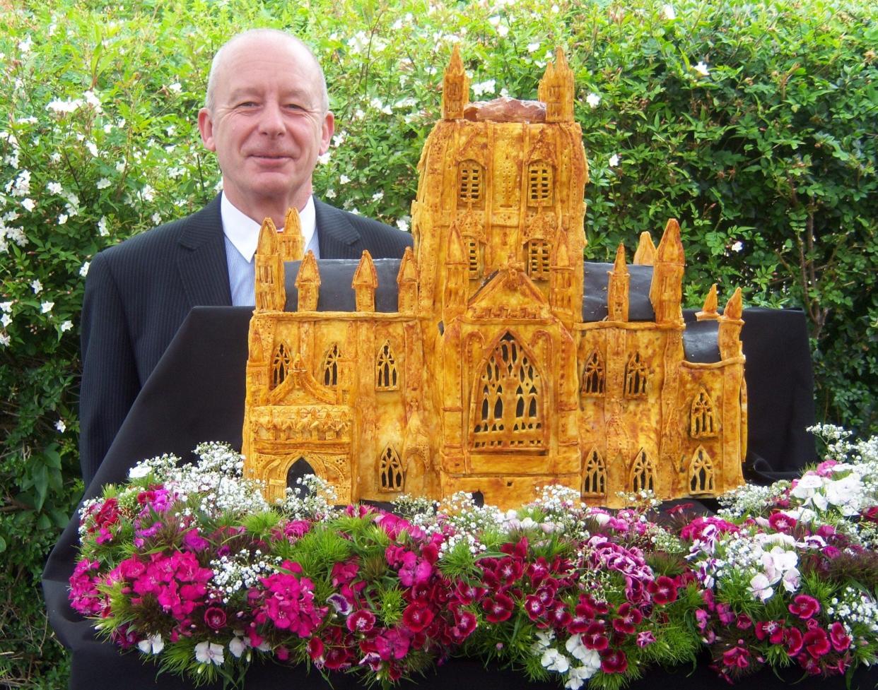English  journalist Martin Kirby is shown in 2012 with the Queen's Jubilee lamprey pie, shaped to resemble Gloucester Cathedral, and made of Great Lakes lampreys shipped from Michigan. Although despised by Michigan anglers, lampreys are prized in England and another pie is likely to be baked for the new monarch, King Charles III, said a spokesman for the Great Lakes Fishery Commission in Ann Arbor.