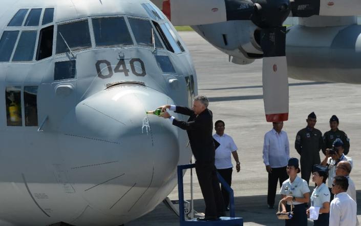 US ambassador to the Philippines, Philip Goldberg, pours champagne on a newl-acquired C-130T cargo plane from the US during the hand-over ceremony at a military base in Manila on October 24, 2016 (AFP Photo/Ted Aljibe)