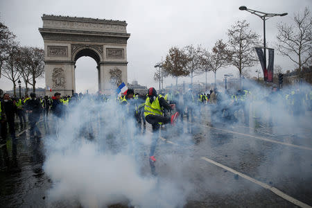 Tear gas fills the air as protesters wearing yellow vests, a symbol of a French drivers' protest against higher diesel taxes, demonstrate near the Arc de Triomphe in Paris, France, December 1, 2018. REUTERS/Stephane Mahe