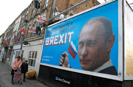 People walk past a billboard poster in London, Britain, November 8, 2018. REUTERS/Peter Nicholls