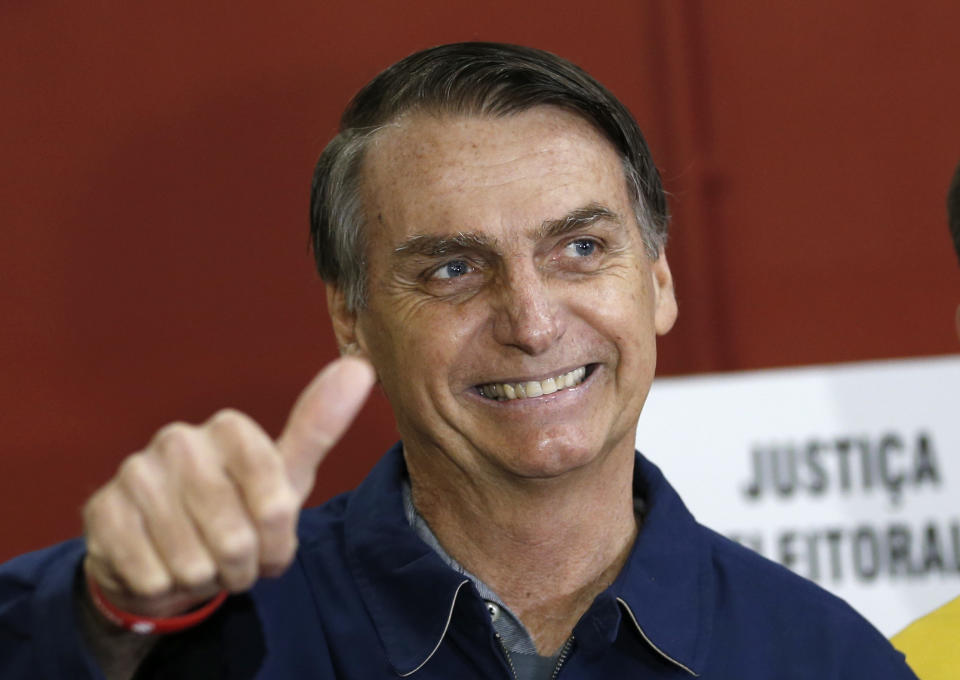 FILE - In this Oct. 7, 2018 file photo, presidential frontrunner Jair Bolsonaro, of the Social Liberal Party, flashes a thumbs up at a polling station in Rio de Janeiro, Brazil. In the first round of voting on Oct. 7, Bolsonaro performed far beyond expectations, nearly winning outright with 46 percent of the vote. (AP Photo/Silvia Izquierdo, File)