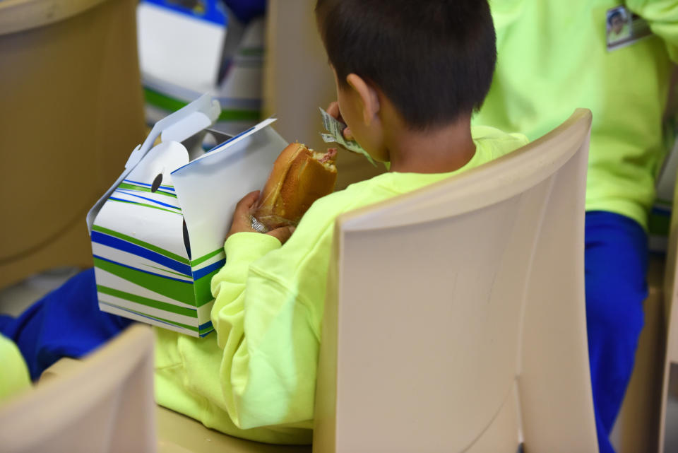 In this Thursday, Aug. 9, 2018, photo, provided by U.S. Immigration and Customs Enforcement, a boy eats at South Texas Family Residential Center in Dilley, Texas. Currently housing 1,520 mothers and their children, about 10 percent are families who were temporarily separated and then reunited under a “zero tolerance policy” that has since been reversed. (Charles Reed/U.S. Immigration and Customs Enforcement via AP)