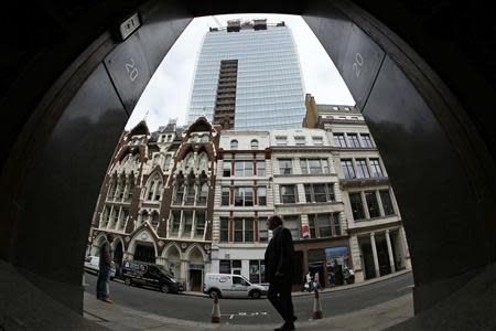 A man walks past suspended parking bays in front of the Walkie Talkie tower in London September 3, 2013. REUTERS/Stefan Wermuth