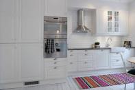 The kitchen inside this eclectic Scandinavian apartment features a gray limestone countertop from Portugal and neutral, light-gray walls. Source: Alvhem Estate & Interior