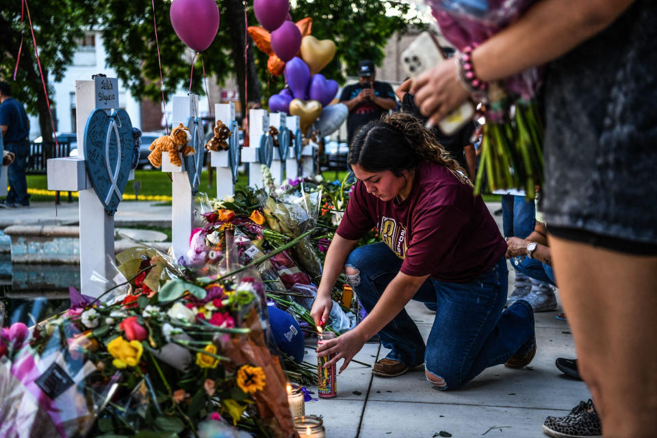 Image: A woman lights a candle at a makeshift memorial outside Uvalde County Courthouse in Uvalde, Texas, on May 26, 2022. (Chandan Khanna / AFP - Getty Images)