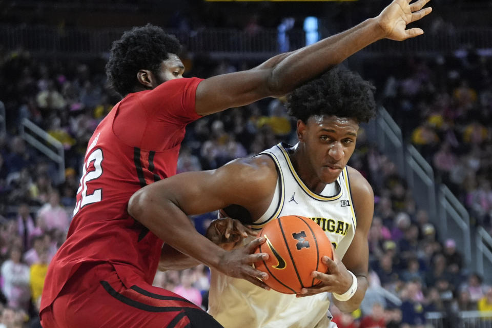 Michigan forward Tarris Reed Jr., right, drives on Rutgers center Emmanuel Ogbole (22) in the second half of an NCAA college basketball game in Ann Arbor, Mich., Saturday, Feb. 3, 2024. (AP Photo/Paul Sancya)