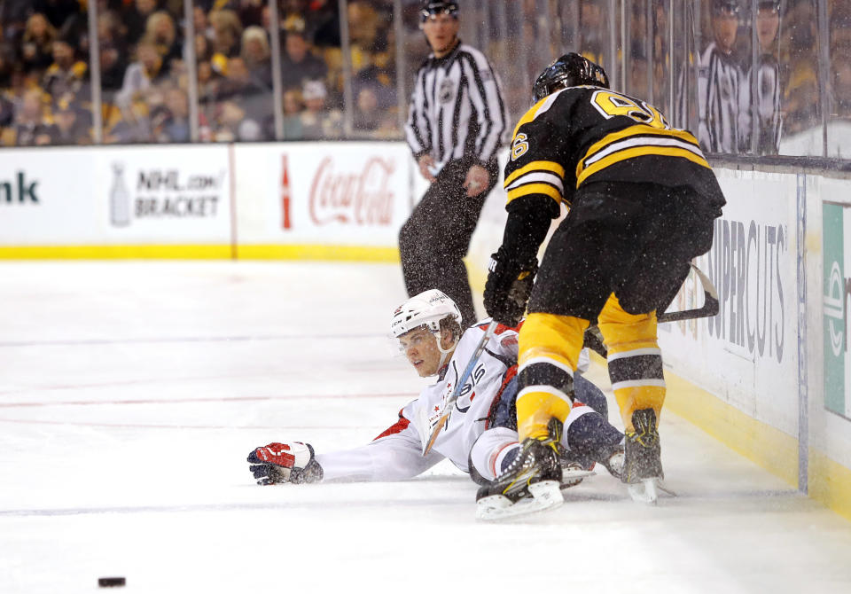 Washington Capitals' Andre Burakovsky is dumped by Boston Bruins' Kevan Miller during the first period of an NHL hockey game in Boston Saturday, April 8, 2017. (AP Photo/Winslow Townson)