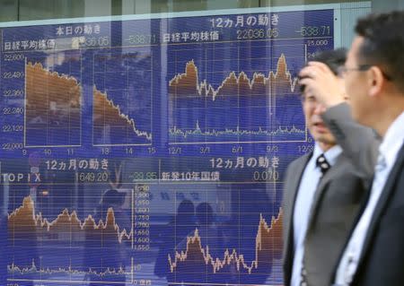 FILE PHOTO: December 4 2018, Tokyo, Japan - Pedestrians pass before a share prices board in Tokyo on Tuesday, December 4, 2018. (Photo by Yoshio Tsunoda/AFLO)