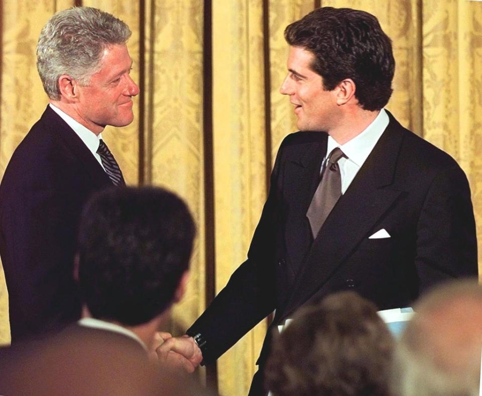 John F Kennedy Jr with President Bill Clinton at the White House in 1998 (AFP via Getty Images)