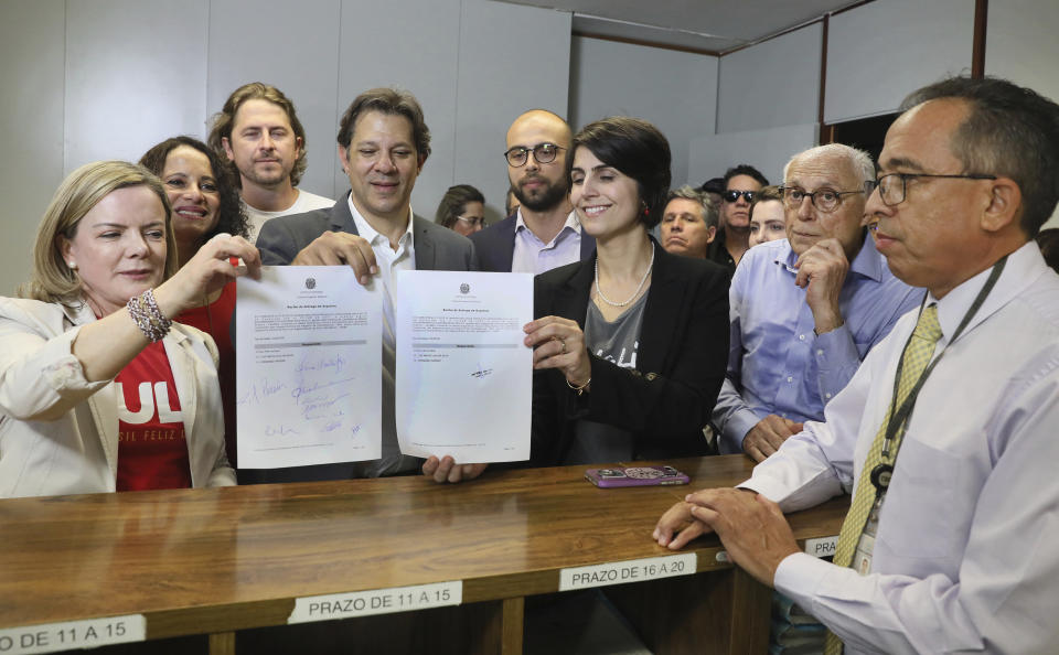 In this photo released by the Supreme Electoral Court, from left, Worker's Party President Senator Gleisi Hoffmann, former Sao Paulo Mayor Fernando Haddad, and state lawmaker from the Communist Party Manuela D'avila, show the presidential candidate registration for jailed, former President Luiz Inacio Lula da Silva, at the Supreme Electoral Court in Brasilia, Brazil, Wednesday, Aug. 15, 2018. The Workers' Party registered the jailed former president as its candidate to run for president on Wednesday, with Haddad as his running-mate. (Supreme Electoral Court/Nelson Jr. via AP)