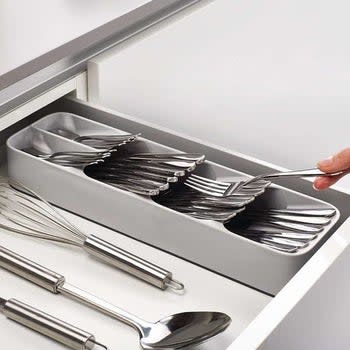 the organizer holding silverware, sitting beside other cooking utensils