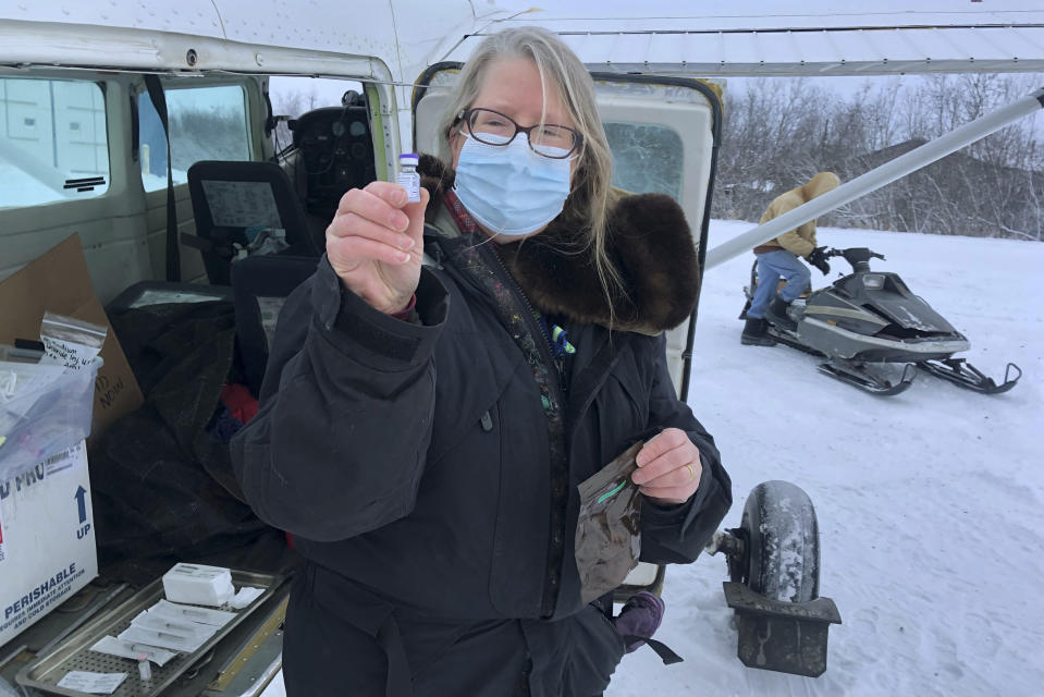 This December 2020 photo provided by Yukon Kuskokwim Health Corporation, Village Service Chief Dr. Elizabeth Roll holds a COVID-19 vaccine in Napakiak, Alaska. Getting the vaccine to the world's farthest corners means delivering it by boat to Maine's islands, traveling by snowmobile to villages in Alaska and navigating complex waterways in Brazil's Amazon. (Yukon Kuskokwim Health Corporation via AP)