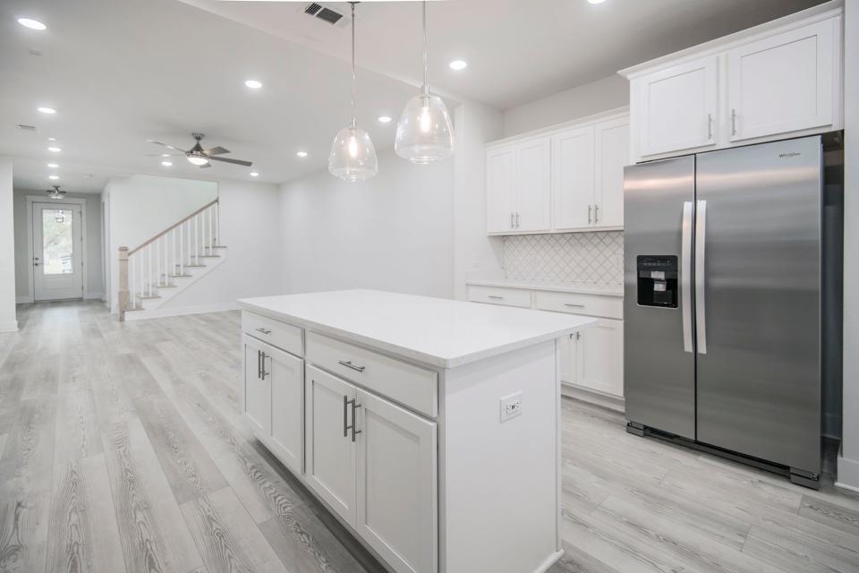 The kitchen features a large prep island and is open to the living area.