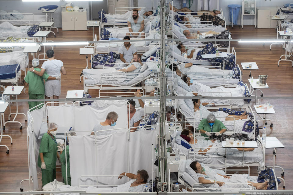 FILE - In this March 4, 2021 file photo, COVID-19 patients rest in a field hospital built inside a sports coliseum in Santo Andre, on the outskirts of Sao Paulo, Brazil. The country has stepped back from the edge — at least for now – as burial and hospital services no longer risk collapse. It has ceased to be the virus global epicenter, as its death toll ebbed. (AP Photo/Andre Penner, File)