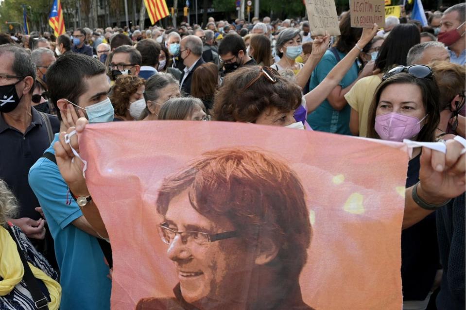 A demonstrator holds a portrait of Carles Puigdemont during a protest in front of the Italian consulate in Barcelona on Friday  (AFP via Getty Images)
