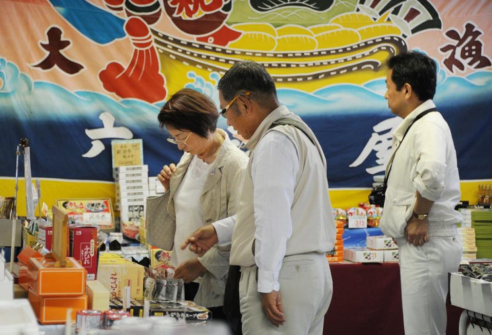 Tourists choose souvenirs during a tour of the site of the 2011 tsunami (Toru Yamanaka/AFP via Getty Images)