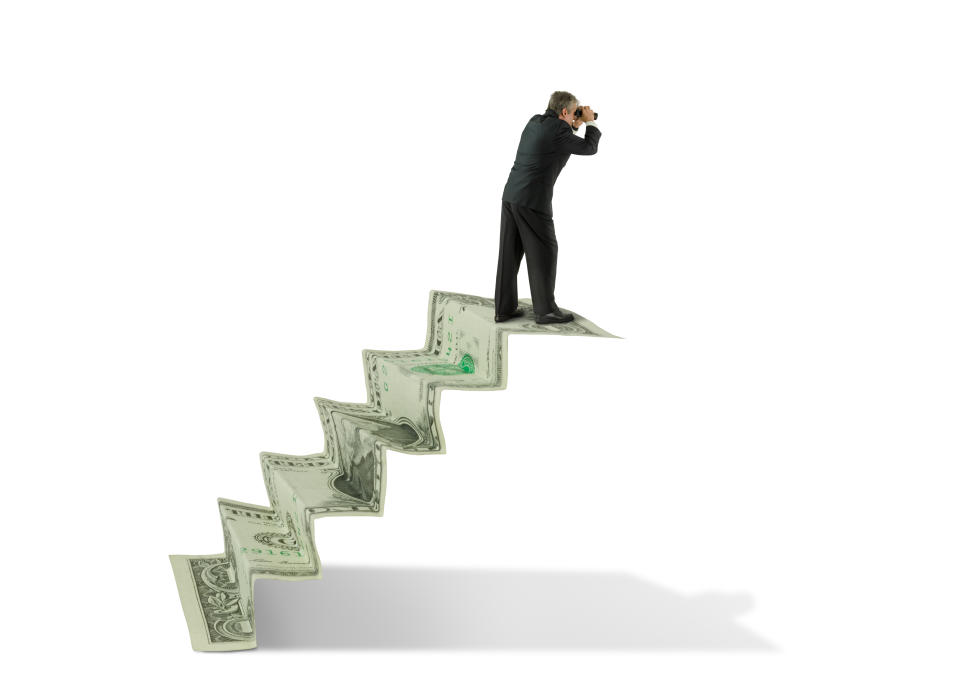 Man on a staircase made of money, looking through binoculars towards the future.