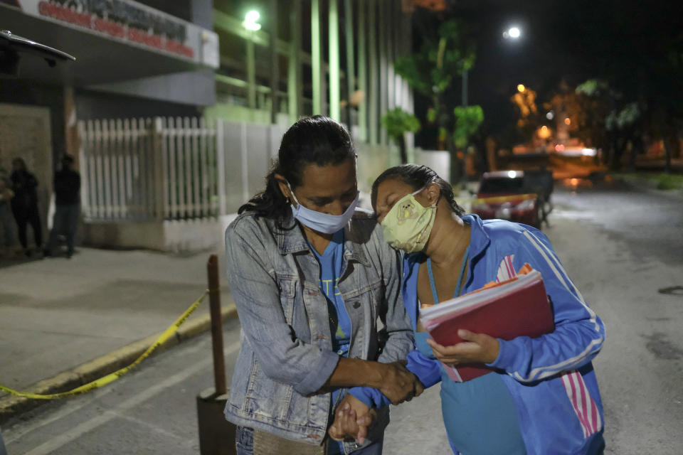 Reaccionando a las contracciones de parto Ada Mendoza, de 24 años, se apoya en su madre cuando salen del Hospital Público Materno Infantil Hugo Chávez Frías luego de que los médicos les ordenaran regresar a casa para esperar contracciones más frecuentes, en el barrio El Valle de Caracas, Venezuela, apenas después de la medianoche del jueves 10 de septiembre de 2020. Mendoza regresó al hospital cuatro horas después y dio a luz a su hija Peyton, luego de cinco horas de trabajo de parto. (AP Foto/Matias Delacroix)