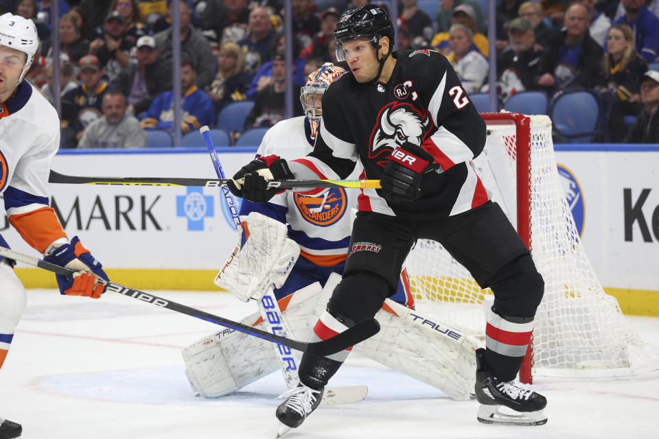 Buffalo Sabres right wing Kyle Okposo, right, looks to tip the puck past New York Islanders goaltender Semyon Varlamov, center, during the first period of an NHL hockey game Saturday, Oct. 21, 2023, in Buffalo, N.Y. (AP Photo/Jeffrey T. Barnes)