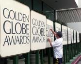 File Photo: Robert Lord uses paint to touch up a sign in the arrivals area at the Beverly Hilton January 22 in Beverly Hills as preparations are made for the Hollywood Foreign Press Associations's annual Golden Globe Awards January 23, which will be telecast to a world-wide audience. REUTERS/Fred Prouser/File Photo