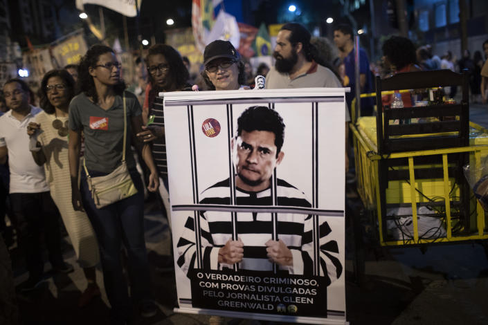FILE - A woman holds a poster depicting Brazil's Justice Minister Sergio Moro behind bars, wearing a prison uniform, during a protest in Rio de Janeiro, Brazil, Thursday, Oct. 3, 2019. When Moro resigned to enter politics, many in Brazil believed the anti-corruption crusader who jailed a popular former president could someday occupy the nation’s most powerful office. But on the eve of Brazil’s Oct. 2 general election, the once-revered magistrate was fighting what polls showed was a losing battle for a Senate seat. (AP Photo/Silvia Izquierdo)