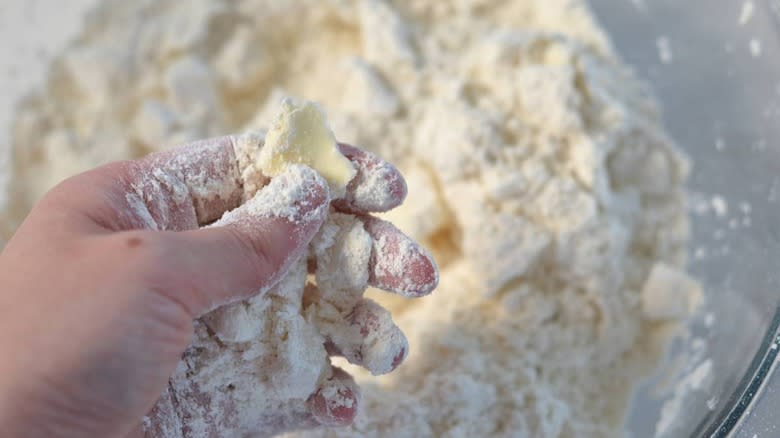 hand holding piece of butter