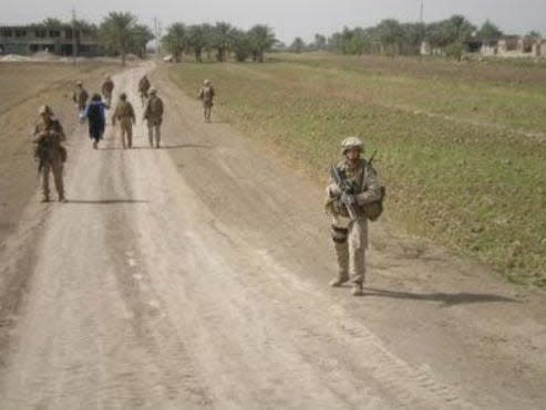 Then Lance Cpl. Billy Olswicki's team on foot patrol in 2008 in Iraq. An interpreter and a sheikh accompany them.