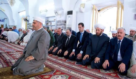 Syria's President Bashar al-Assad (3rd R) attends prayers on the first day of the Muslim holiday of Eid al-Fitr, inside a mosque in Hama, in this handout picture provided by SANA on June 25, 2017, Syria. SANA/Handout via REUTERS