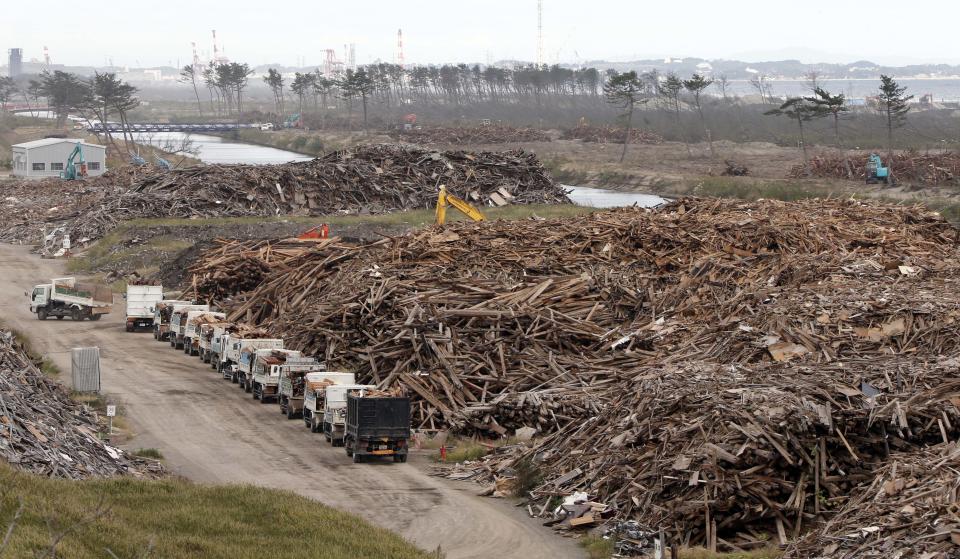 In this Oct. 10, 2012 photo, a yellow crane is seen in the heap of the sorted out rubble of the March 11, 2011 earthquake and tsunami, at the rubble collection site near the Arahama beach in Sendai, northeastern Japan. Japan's accounting of its budget for reconstruction from the disasters is crammed with spending on unrelated projects, while all along Japan's northeastern coast, dozens of communities remain uncertain of whether, when and how they will rebuild. (AP Photo/Koji Sasahara)