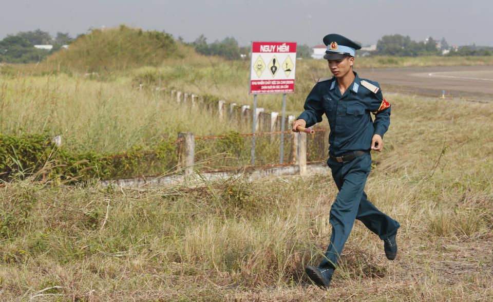 A Vietnamese soldier runs past the dioxin contaminated area when U.S. Secretary of Defense Jim Mattis visited Bien Hoa airbase, where the U.S. army stored the defoliant Agent Orange during the Vietnam War, in Bien Hoa city, outside Ho Chi Minh city, Vietnam, Wednesday, Oct. 17, 2018. (Kham/Pool Photo via AP)