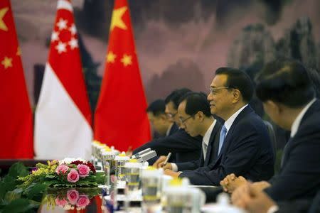 Chinese Premier Li Keqiang, second from right, is flanked by Singaporean and Chinese flags as he speaks with Singaporean President Tony Tan, not shown, during a bilateral meeting at the Great Hall of the People in Beijing, Friday, July 3, 2015. REUTERS/Mark Schiefelbein/Pool