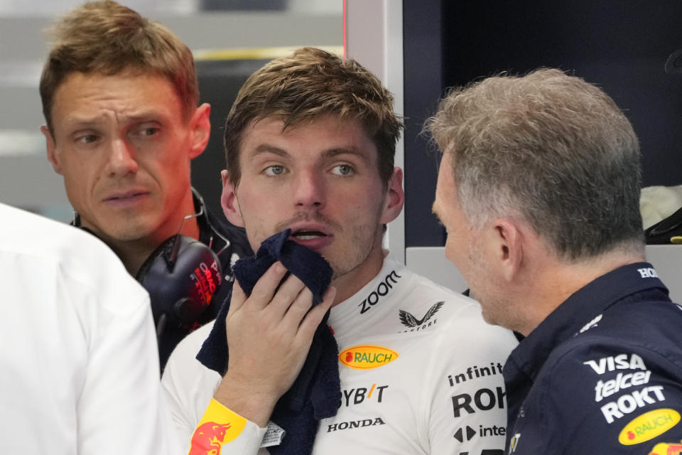 Red Bull driver Max Verstappen of the Netherlands, center, talks to team principal Christian Horner, right, during the second practice session of the Singapore Formula One Grand Prix at the Marina Bay Street Circuit, in Singapore, Friday, Sept. 20, 2024. (AP Photo/Vincent Thian)