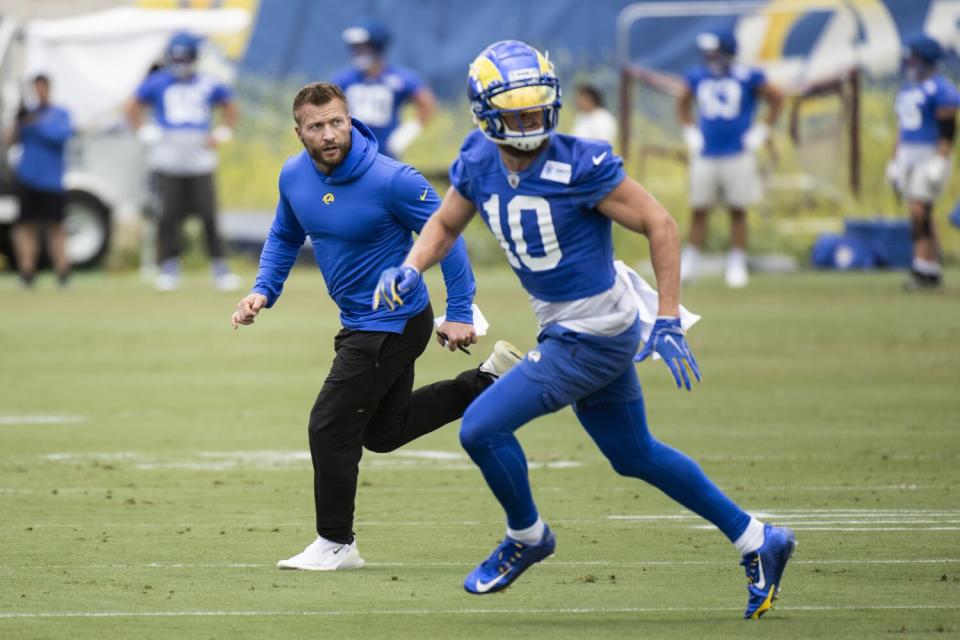 Rams receiver Cooper Kupp (10) runs a drill with coach Sean McVay.